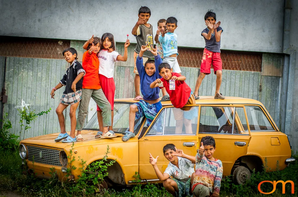 Children playing on an abandoned car